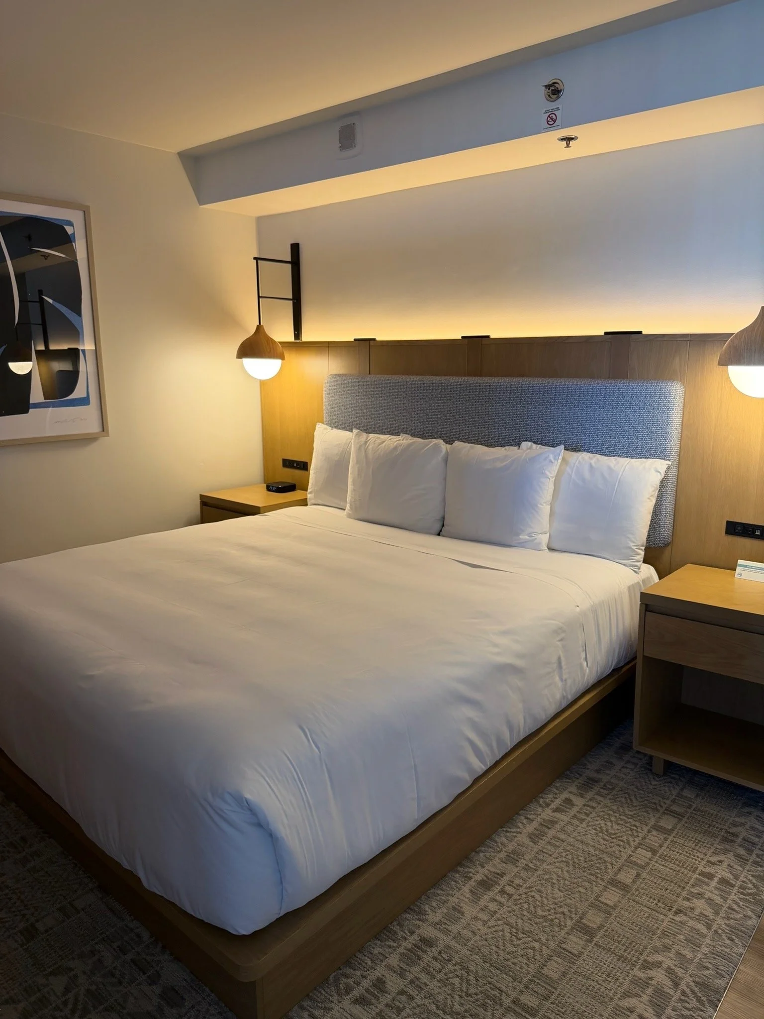 Modern king bedroom at Hyatt Regency Waikiki Beach Resort & Spa featuring minimalist design, warm lighting, and comfortable bedding in Honolulu, Oahu, Hawaii.