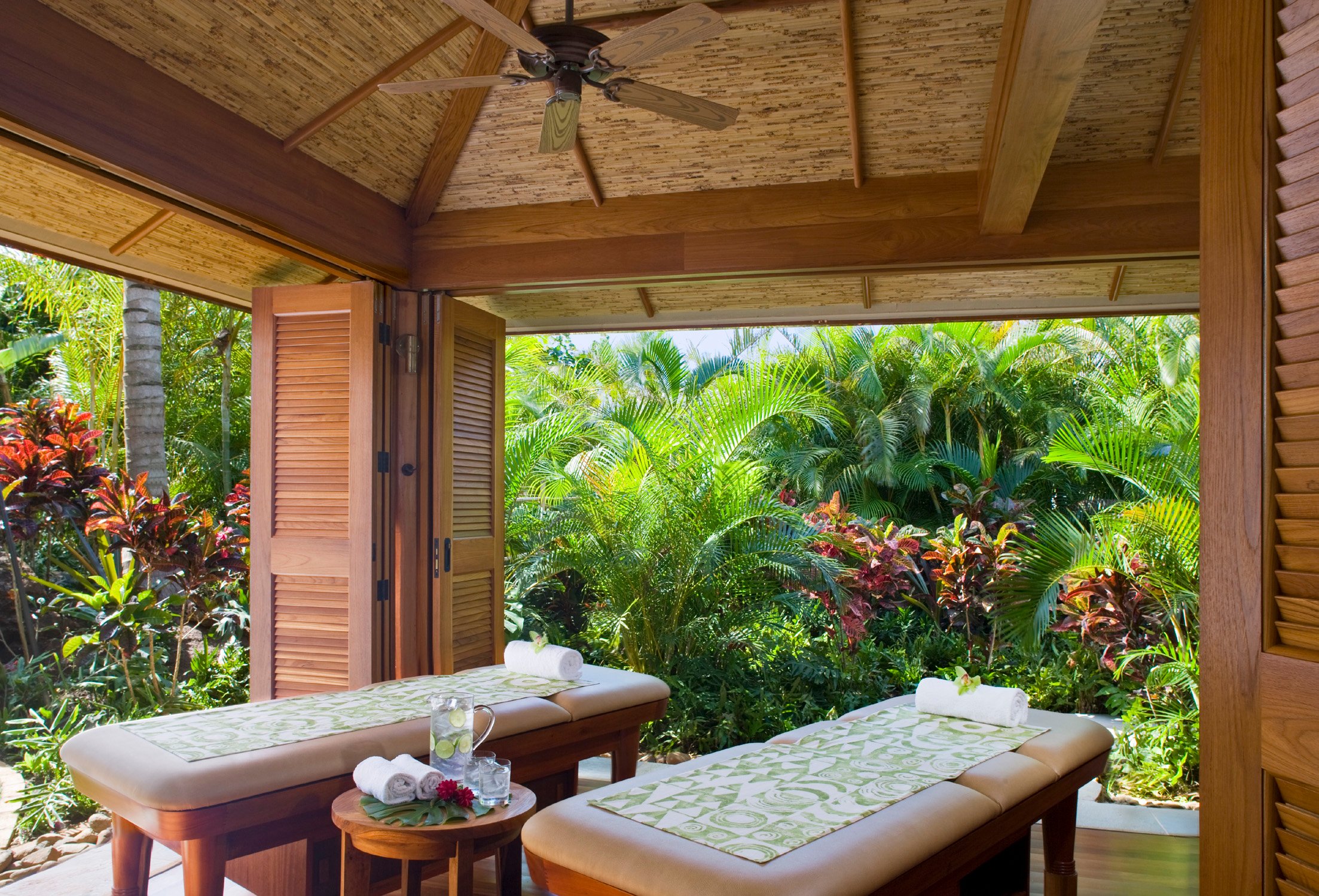 Couples massage treatment room at Anara Spa at Grand Hyatt Kauai Resort & Spa featuring open-air tropical garden views in Poipu, Kauai, Hawaii.