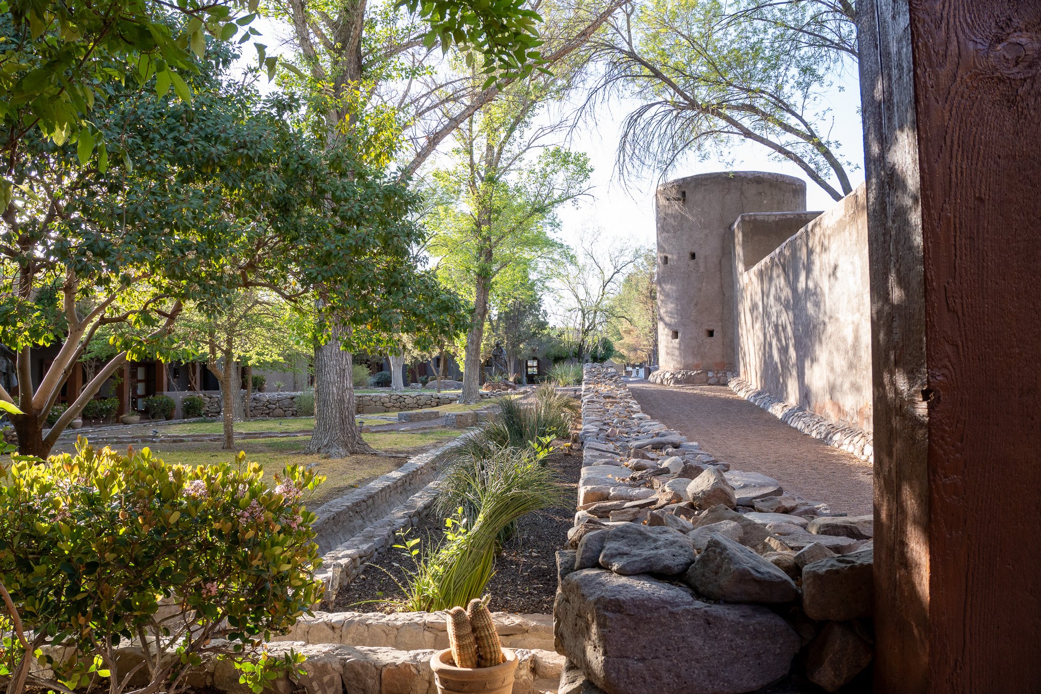 Historic adobe architecture and landscaped courtyard at Cibolo Creek Ranch surrounded by desert greenery in Texas