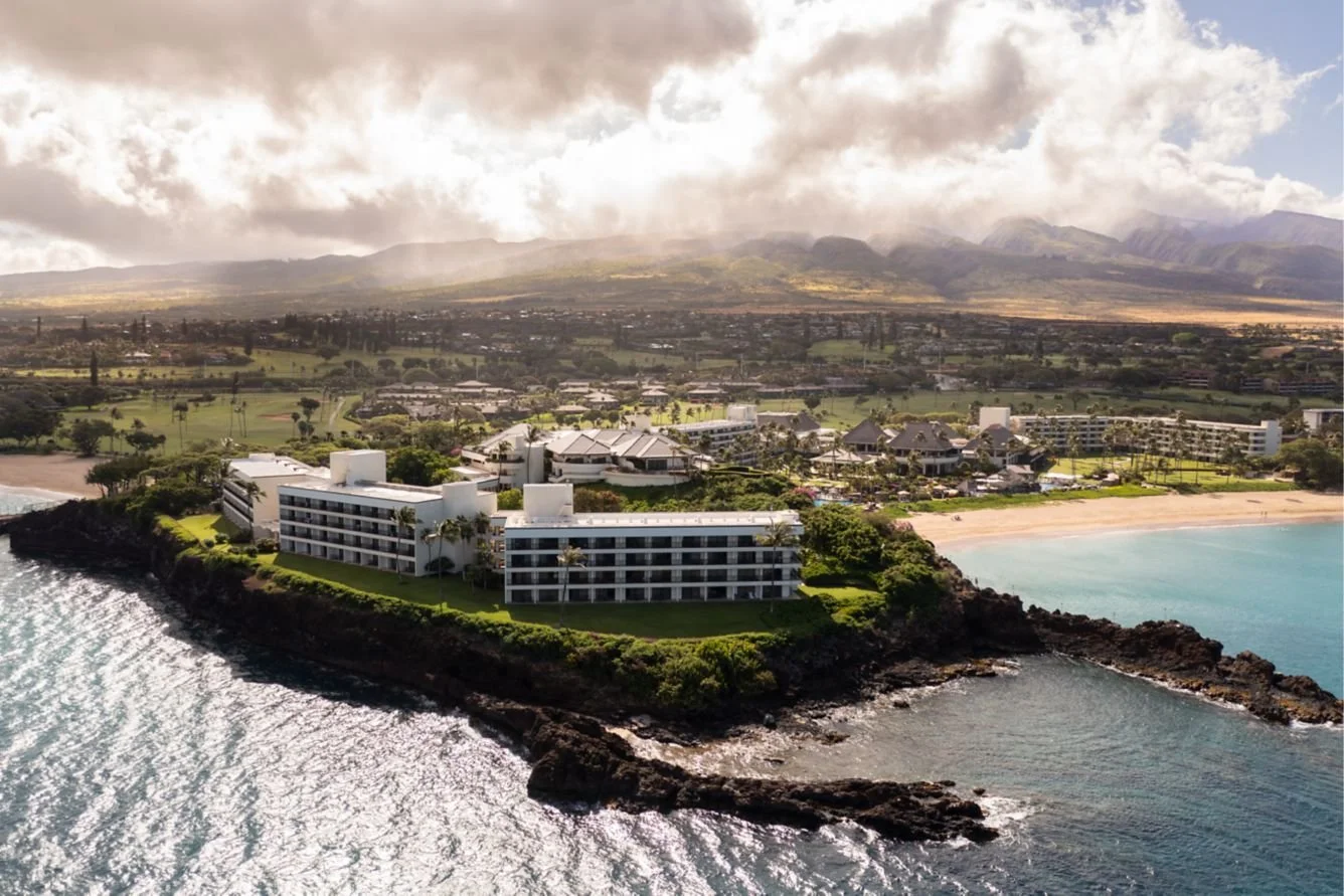 Sheraton Maui Resort & Spa aerial view on a coastal cliff in Kaanapali, with oceanfront buildings, beach, and lush Hawaiian landscape.