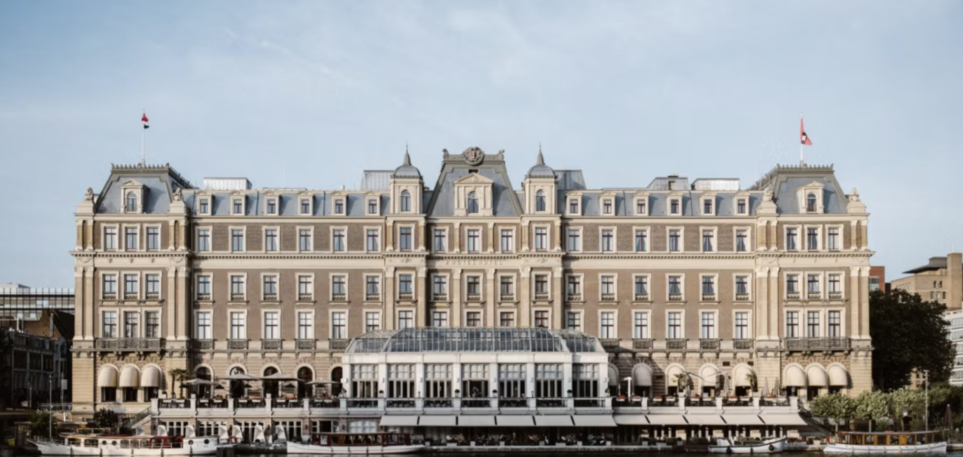 InterContinental Amstel Amsterdam exterior along the Amstel River, showcasing its grand historic façade and waterfront terrace.