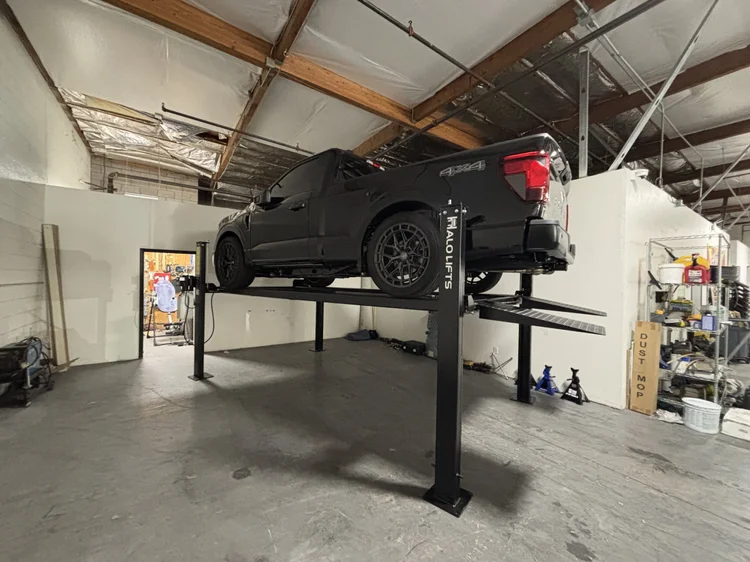 Truck on a four post lift in a shop