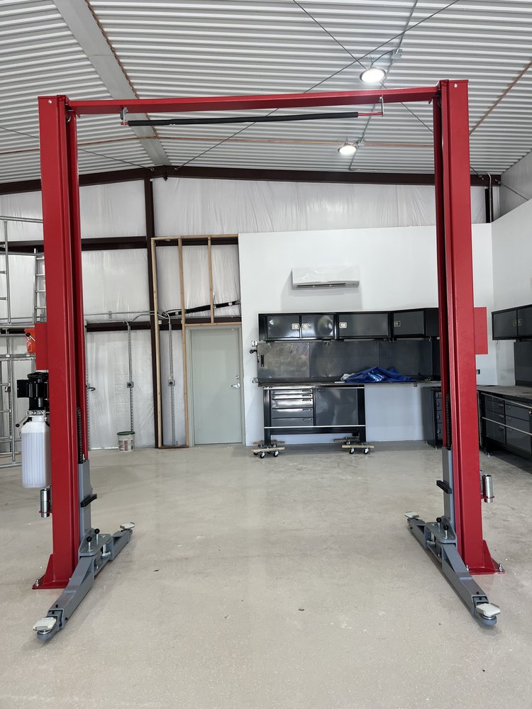 Red two post lift installed in a garage