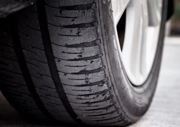 Close-up of a car tire with detailed tread pattern.