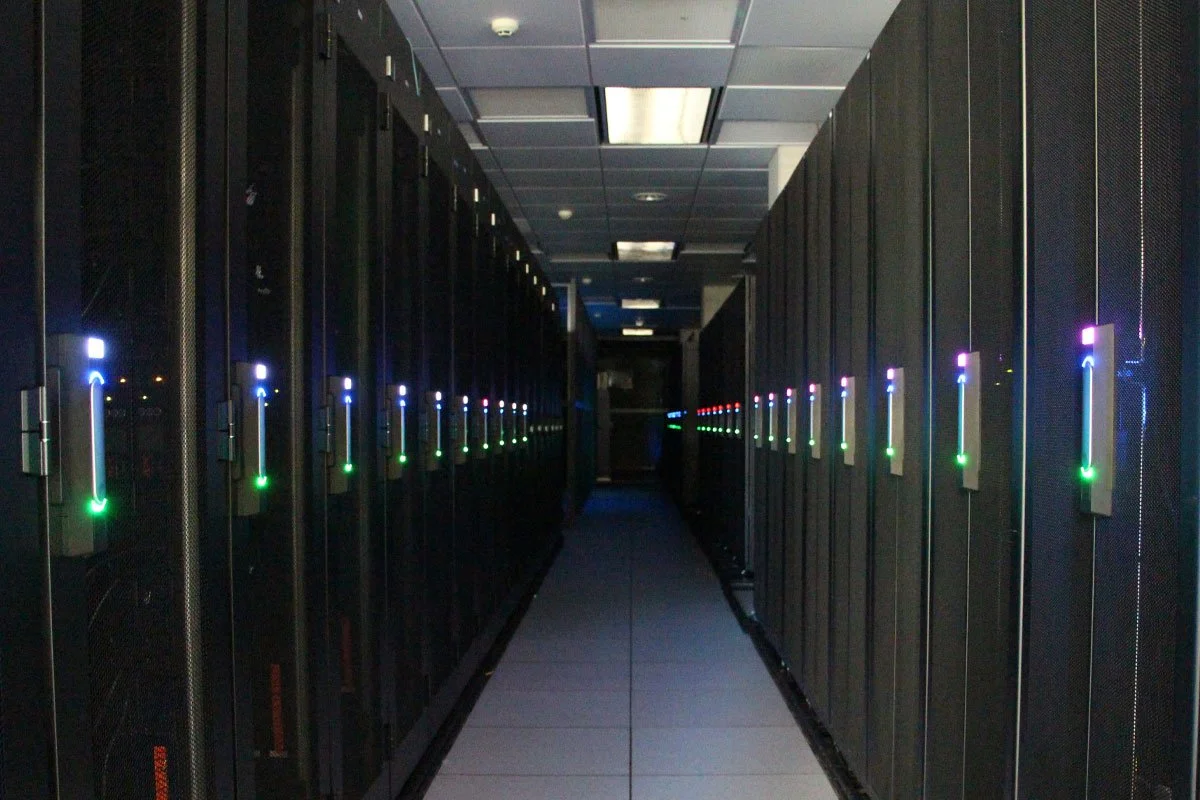 Data centre hallway with server racks representing research computing providers, HPC systems, cloud infrastructure, and storage services.