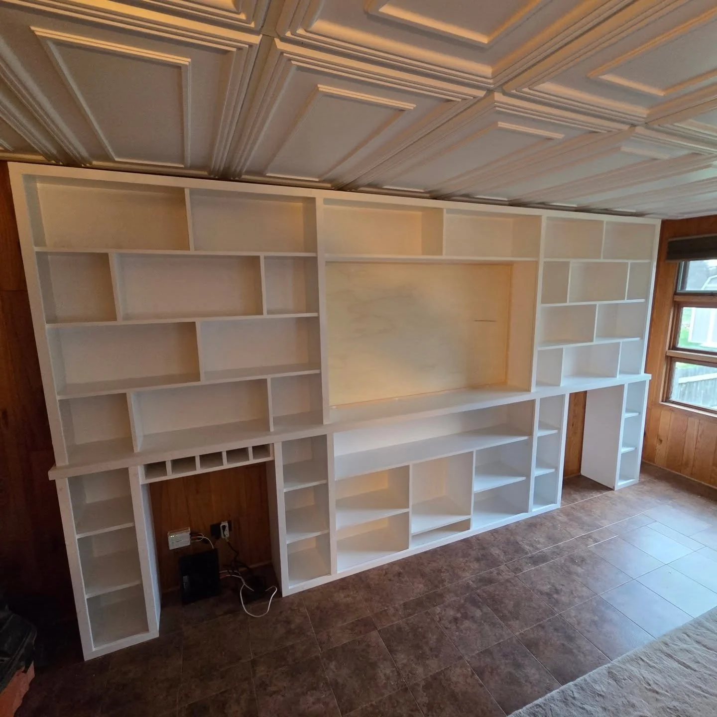 Custom built in shelving unit made for tv, fireplace, fridge, and lots of books. #builtins #carpentry #benjaminmoorepaint
