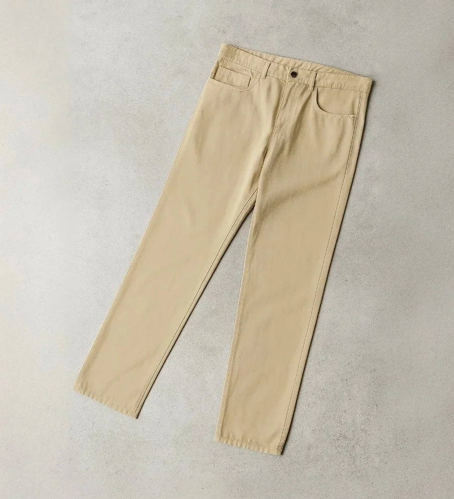 A pair of beige pants laid flat on a light gray surface.