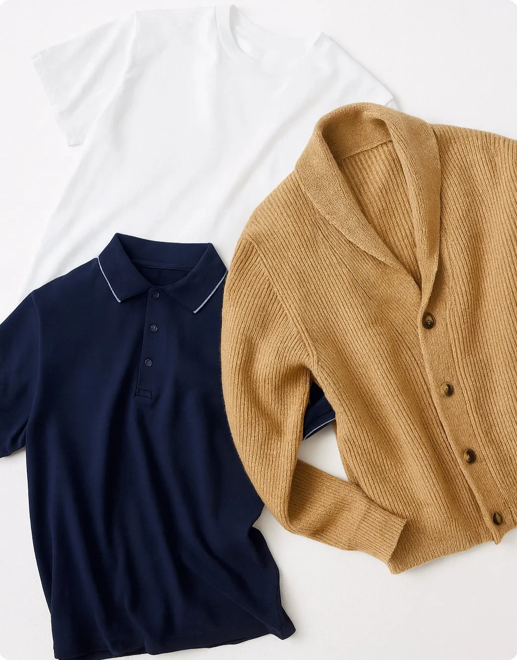 Three shirts laid flat: a plain white T-shirt, a navy blue polo with a collar and buttons, and a tan cardigan with buttons.