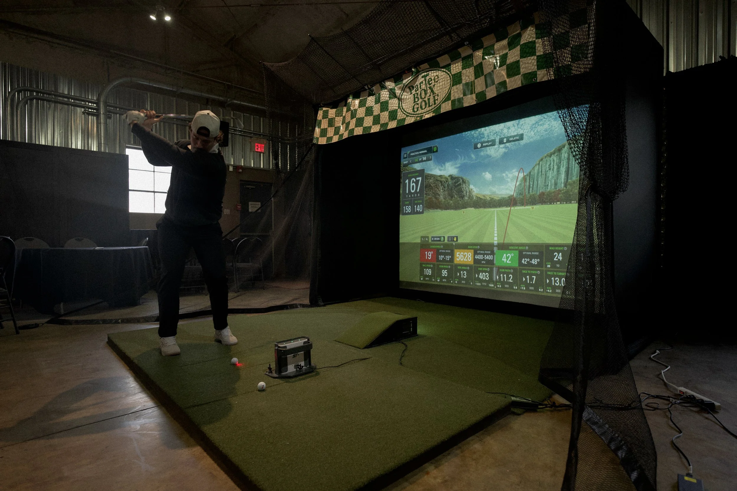 Guest playing the ParTee Box Golf simulator at an indoor corporate event