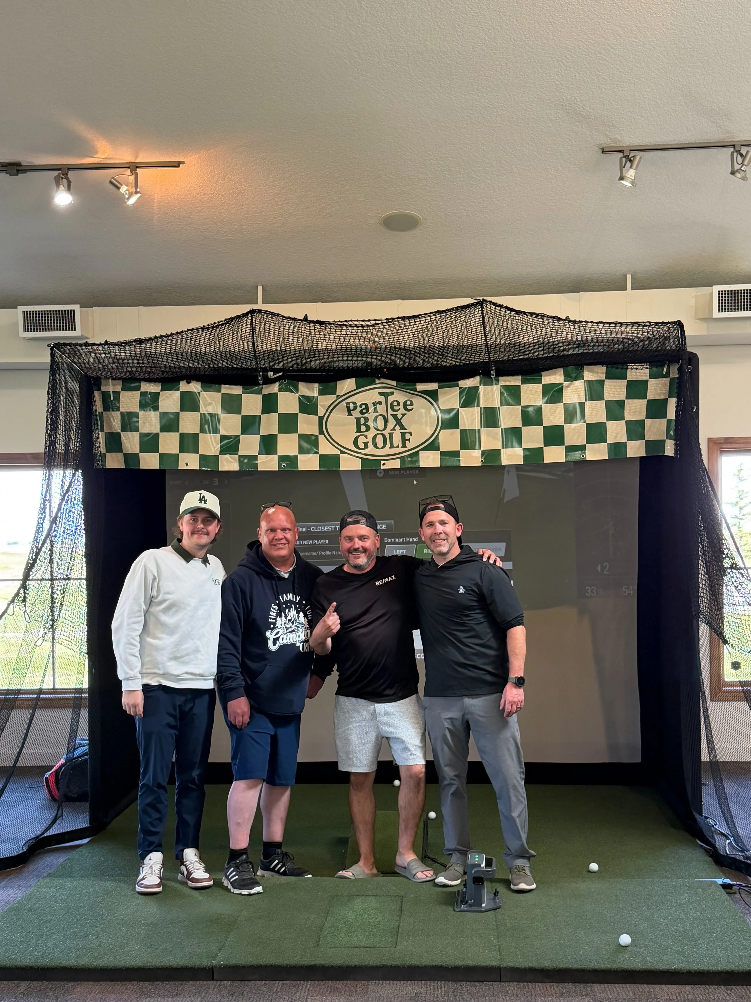 Group of guests posing in front of the ParTee Box Golf simulator at a fundraising  event in Calgary