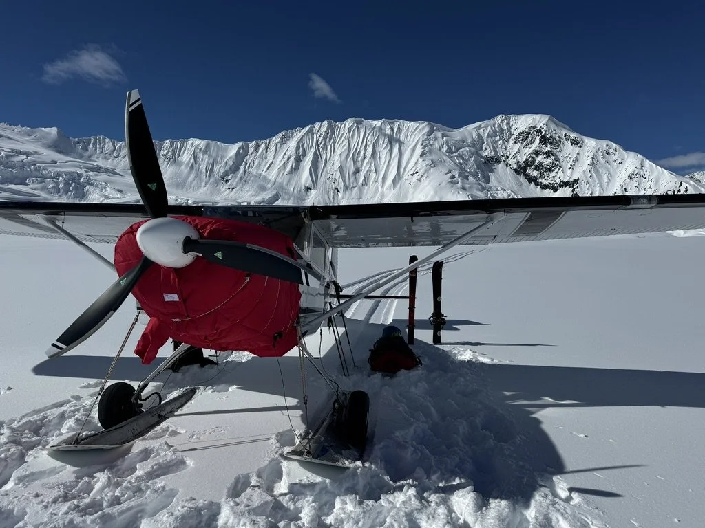 Cessna 180 ski plane near a snowy mountain in Alaska