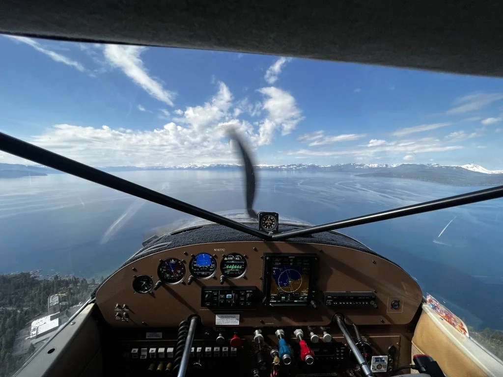 Cessna 180 bush plane flying over Lake Tahoe