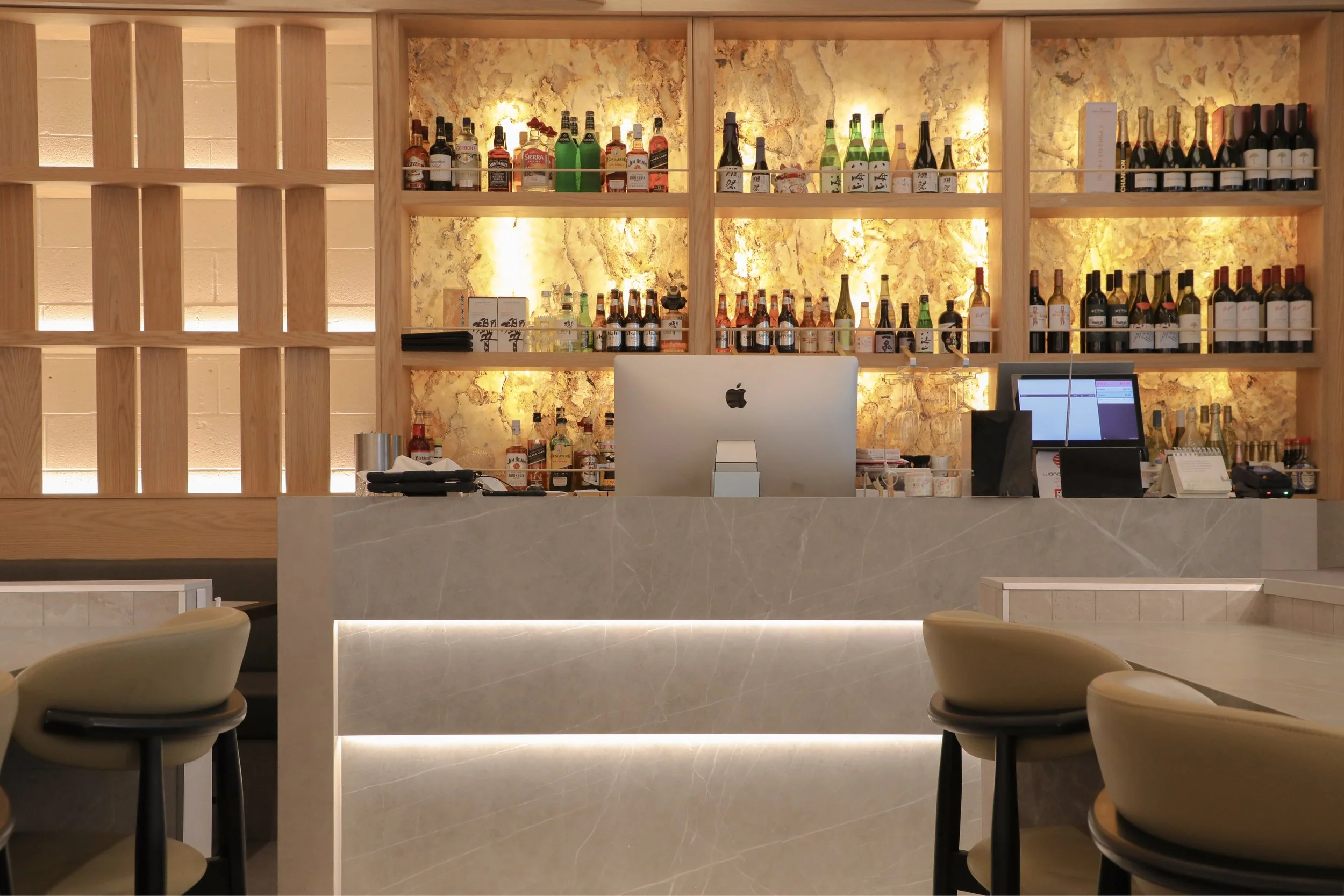 Completed hospitality fit-out for Wonder Sushi Norwest, showcasing a custom bar design with stone detailing, feature lighting and integrated beverage display.