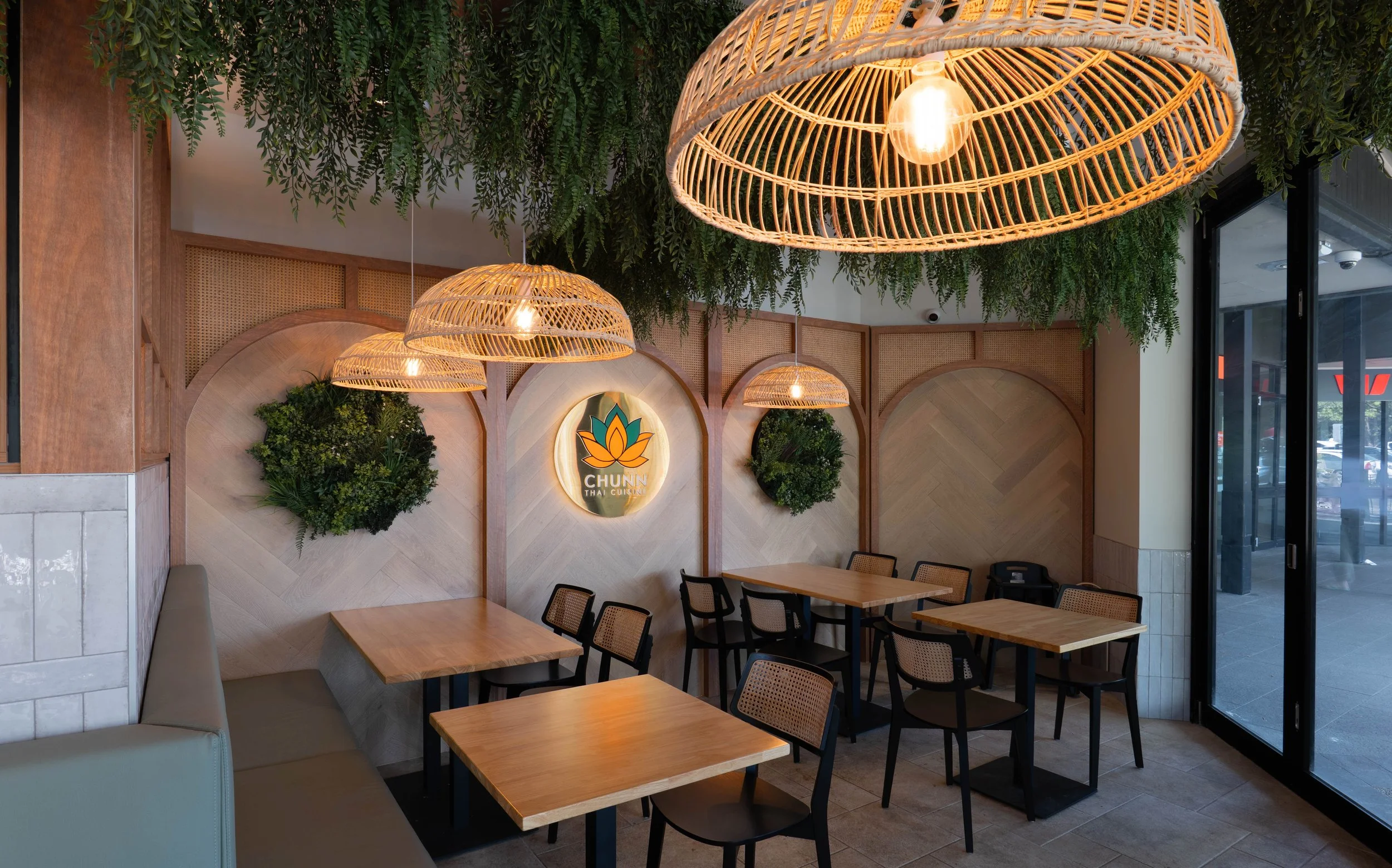Chunn Thai Menai restaurant featuring a custom timber feature wall with integrated illuminated signage and warm material finishes.