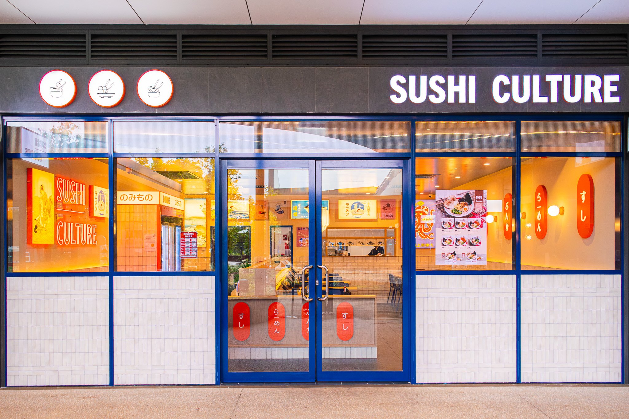 Sushi Culture Japanese restaurant shopfront with bold orange and blue branding and street-facing glazing.
