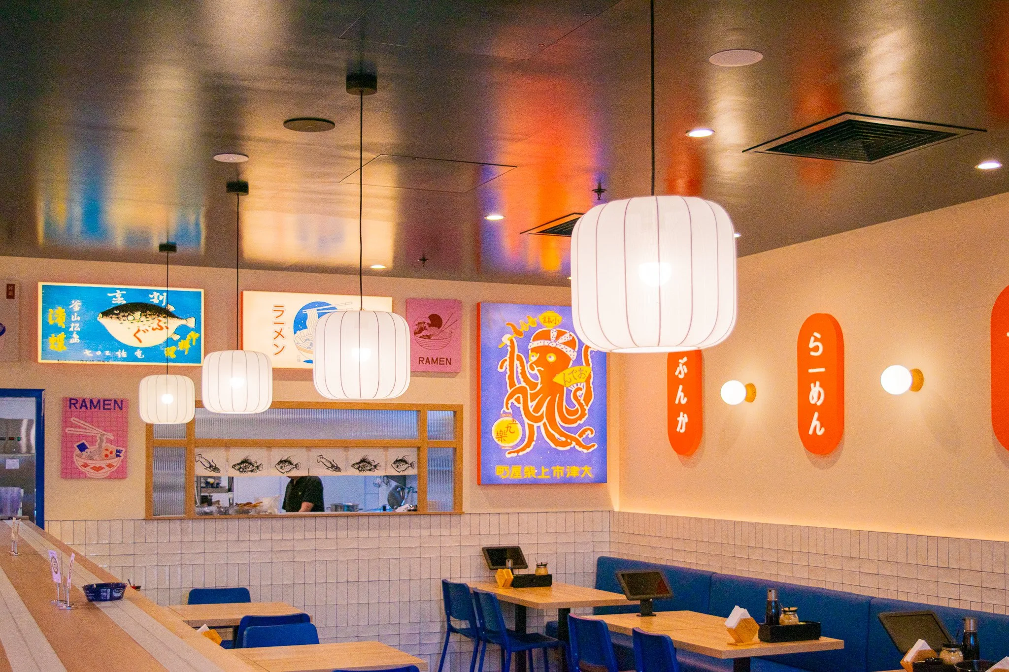 Modern Japanese restaurant dining area with timber finishes, booth seating and pendant lighting.