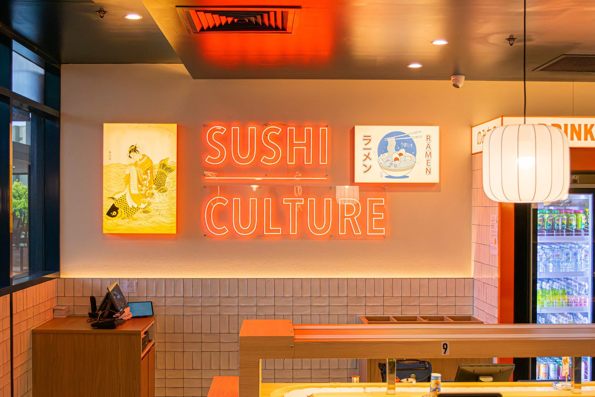 Custom service counter with illuminated signage, timber detailing and point-of-sale area.