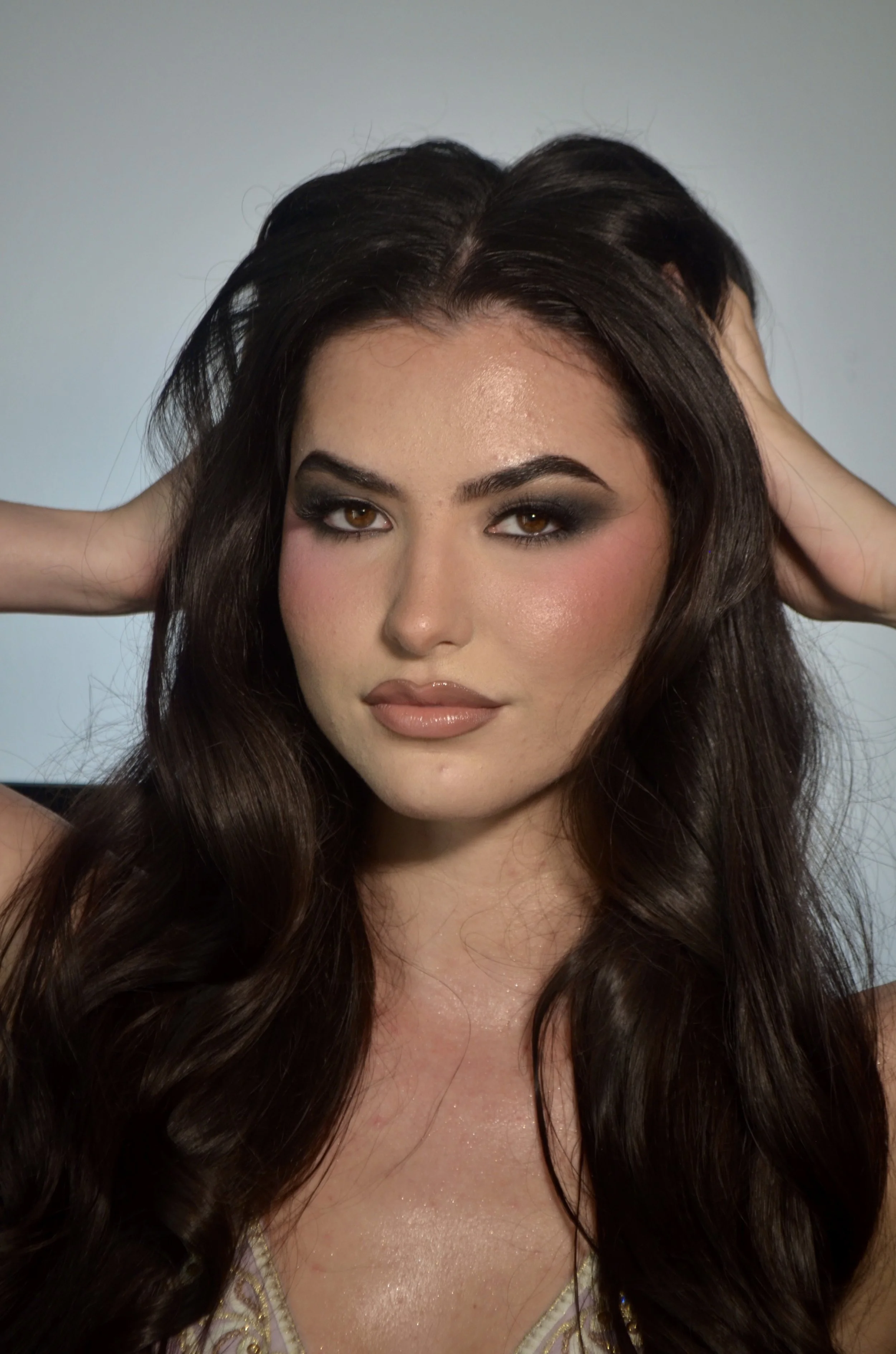 Boise makeup artist glam look with bronzed glowing skin, soft Smokey eyeshadow, bold brows and glossy nude lips.