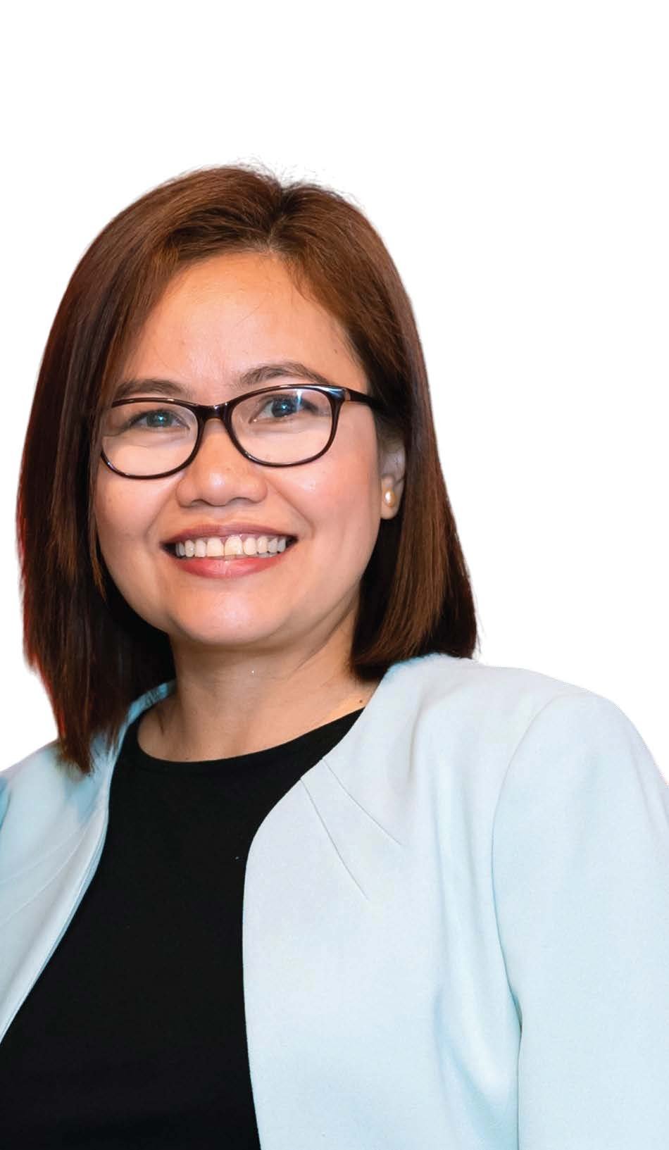 A woman with glasses and shoulder-length brown hair smiling against a plain white background.
