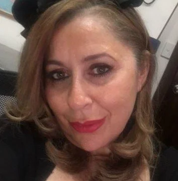 A woman with blonde hair and makeup, smiling at the camera.