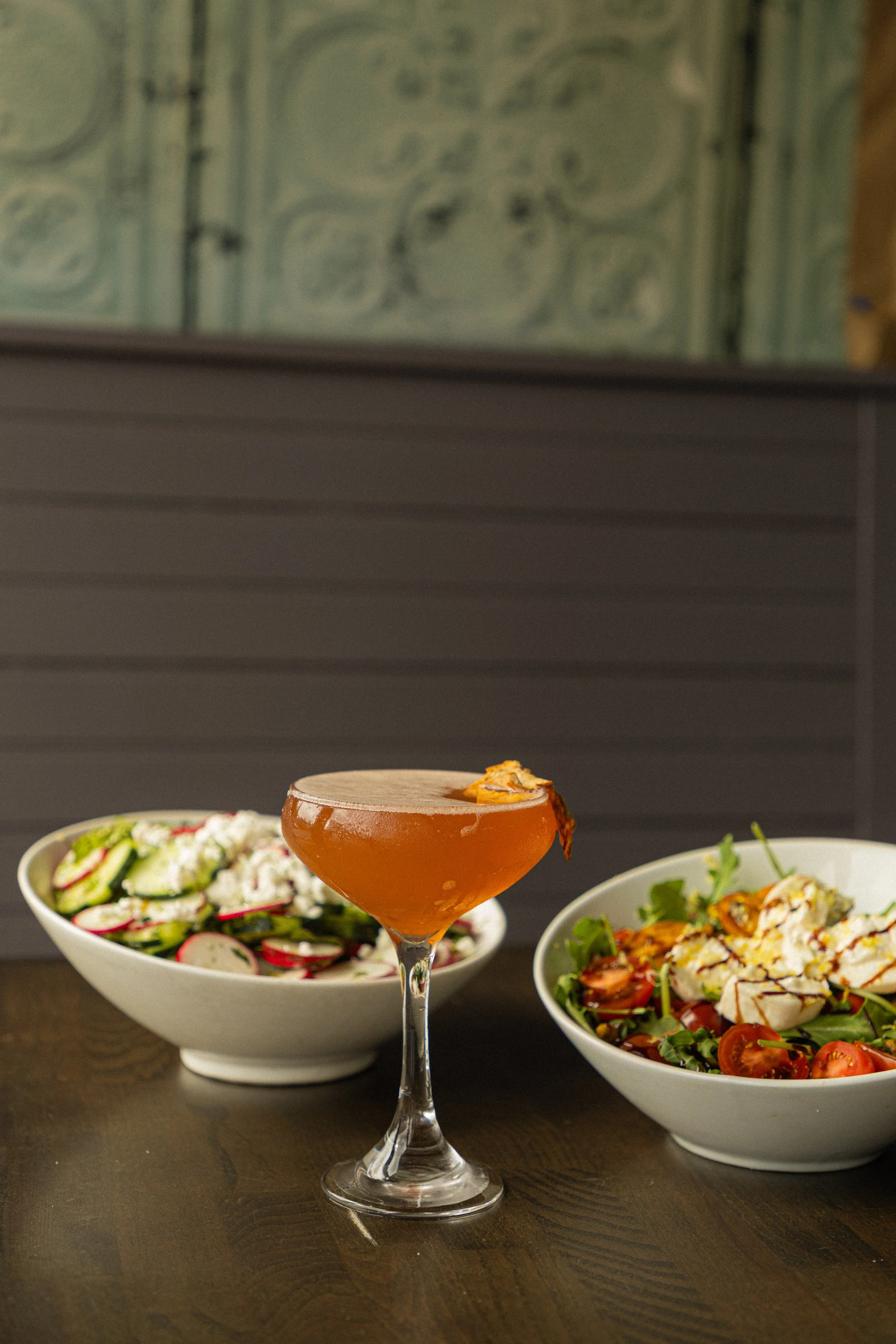 Cucumber Salad and Burrata Salad behind an Apple Crisp-tini