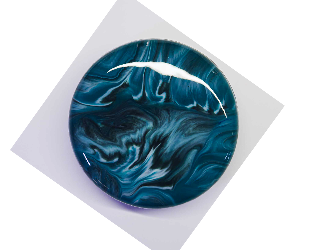 Luxury round entremet dessert by AFTERSIX with blue marble mirror glaze, presented on a white base against a dark background.