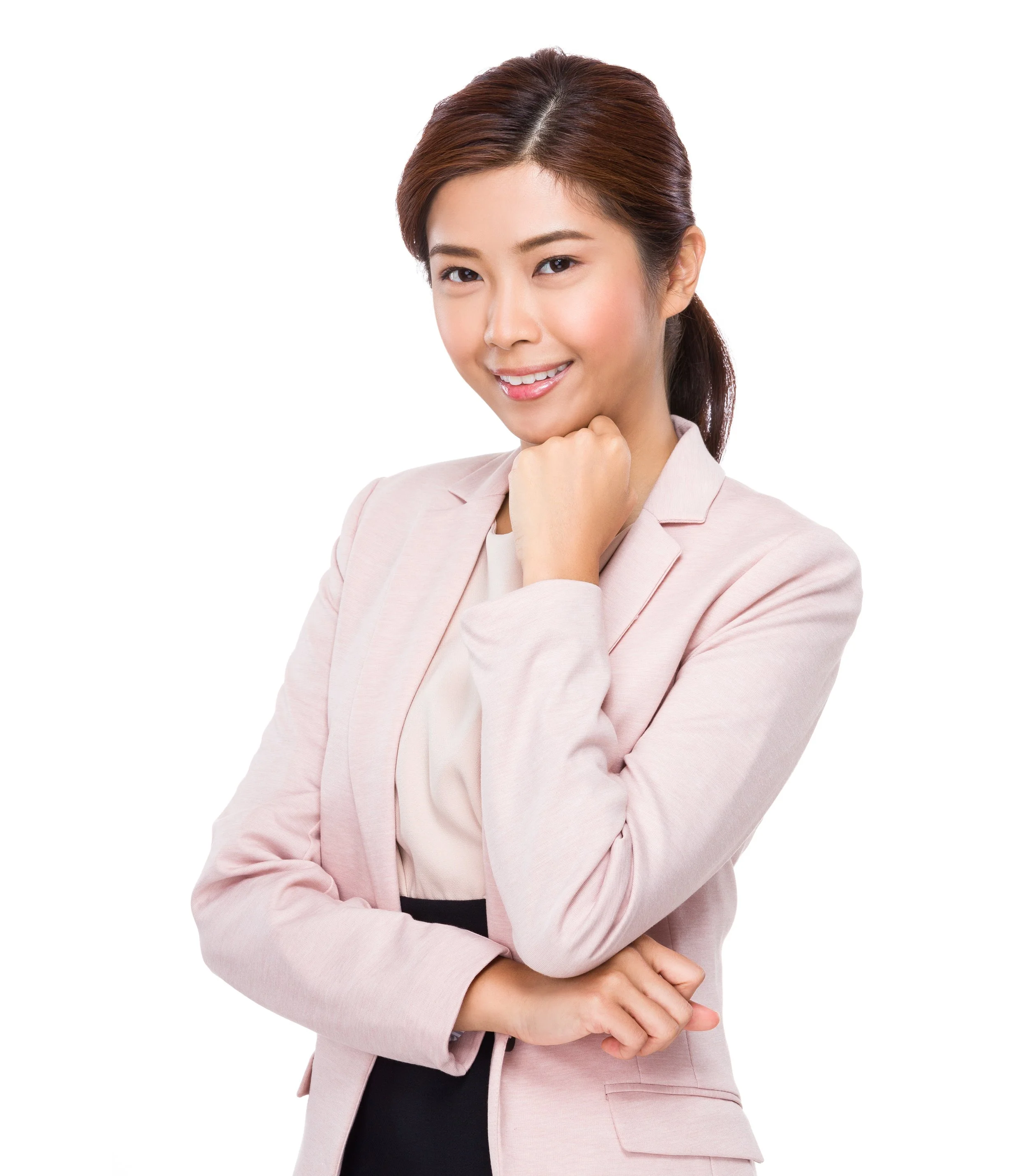 A confident young woman in a light pink blazer smiling with her chin resting on her hand, against a plain white background.