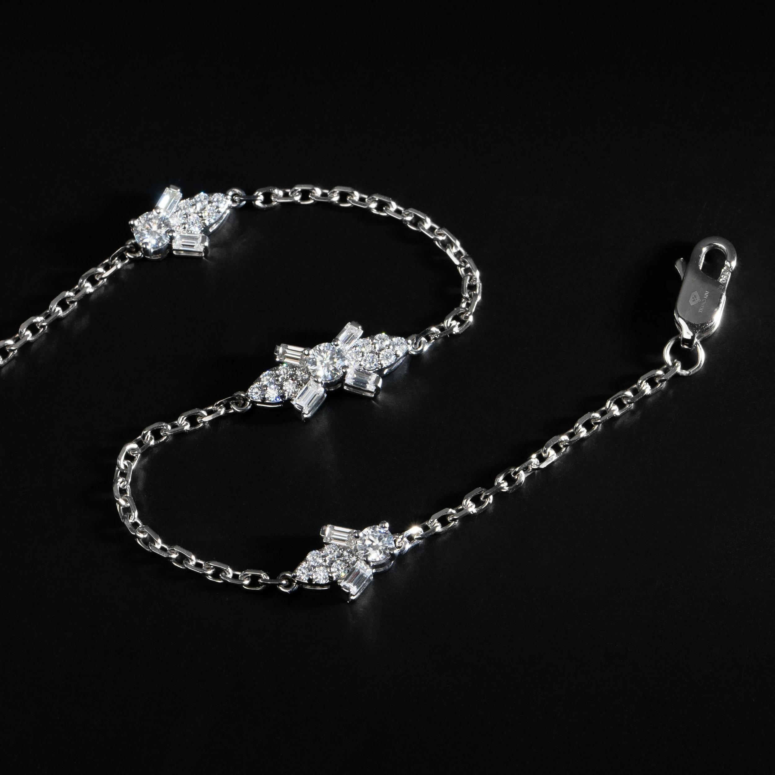 Elegant silver bracelet with sparkling diamonds laid on a black background