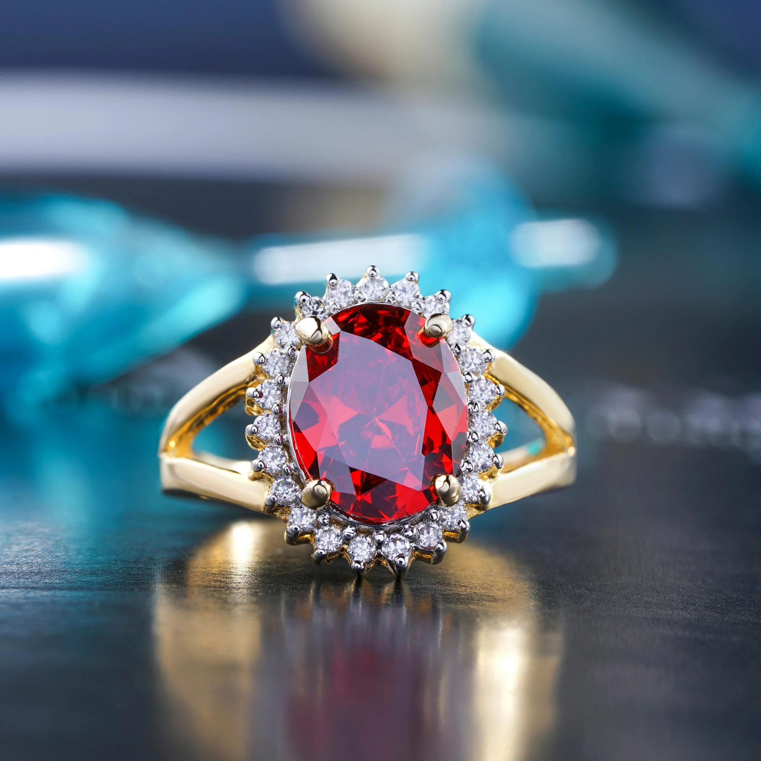 A gold ring with an oval red gemstone surrounded by small white diamonds.