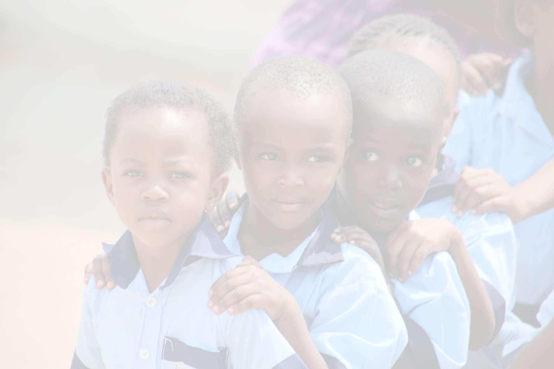 Trois enfants africains en uniformes scolaires posant par groupe en extérieur.