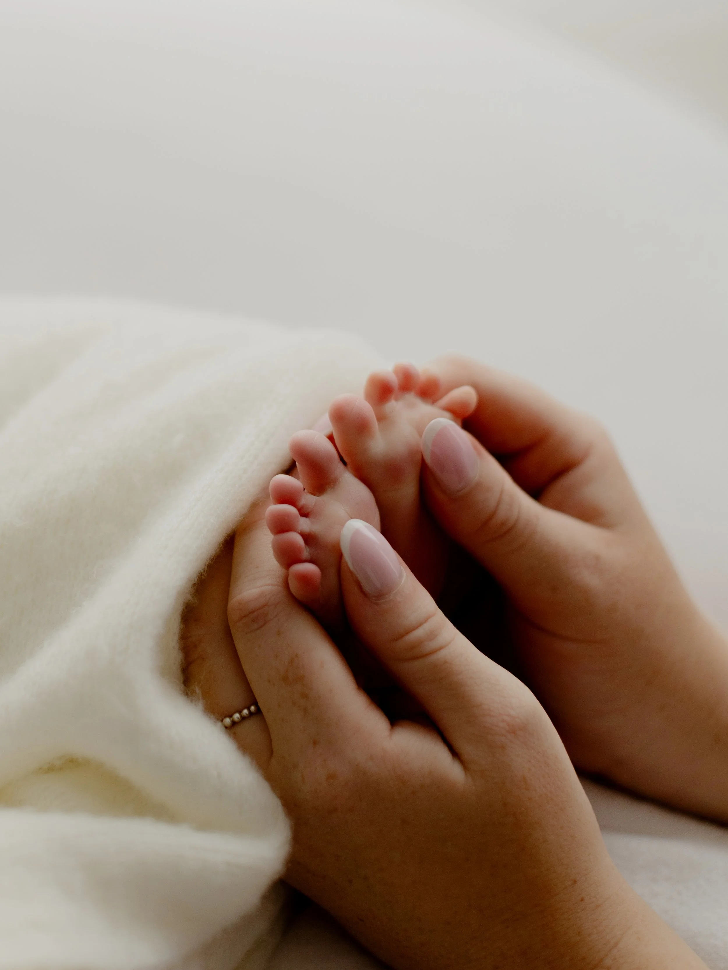 Baby's feet mums hands