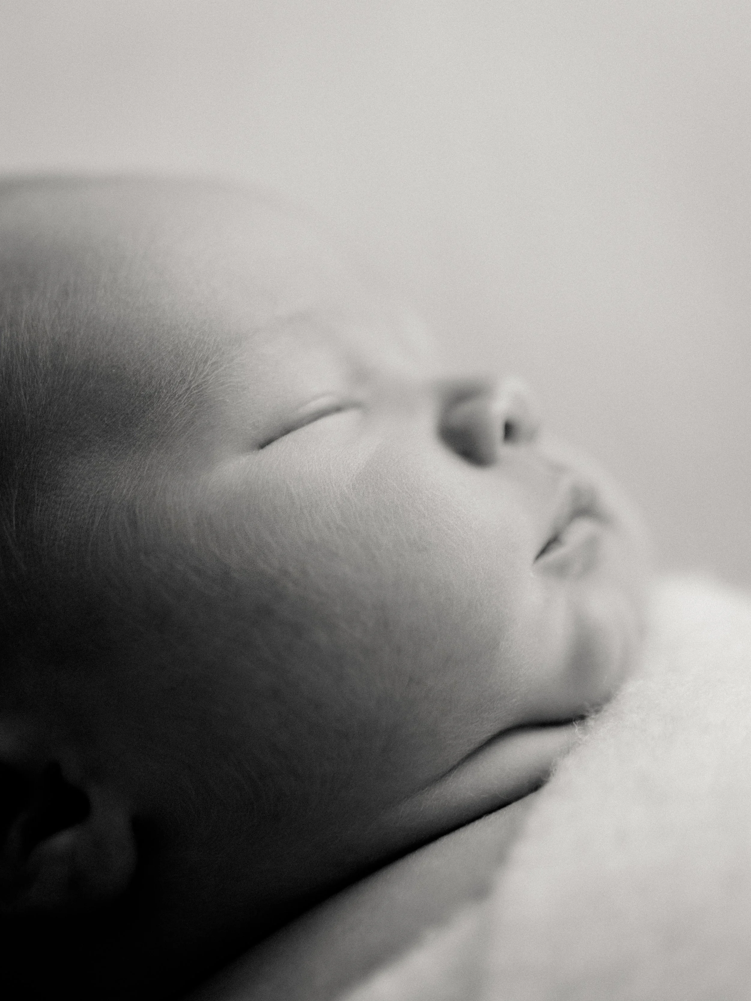 Black and white close-up portrait of a sleeping newborn baby