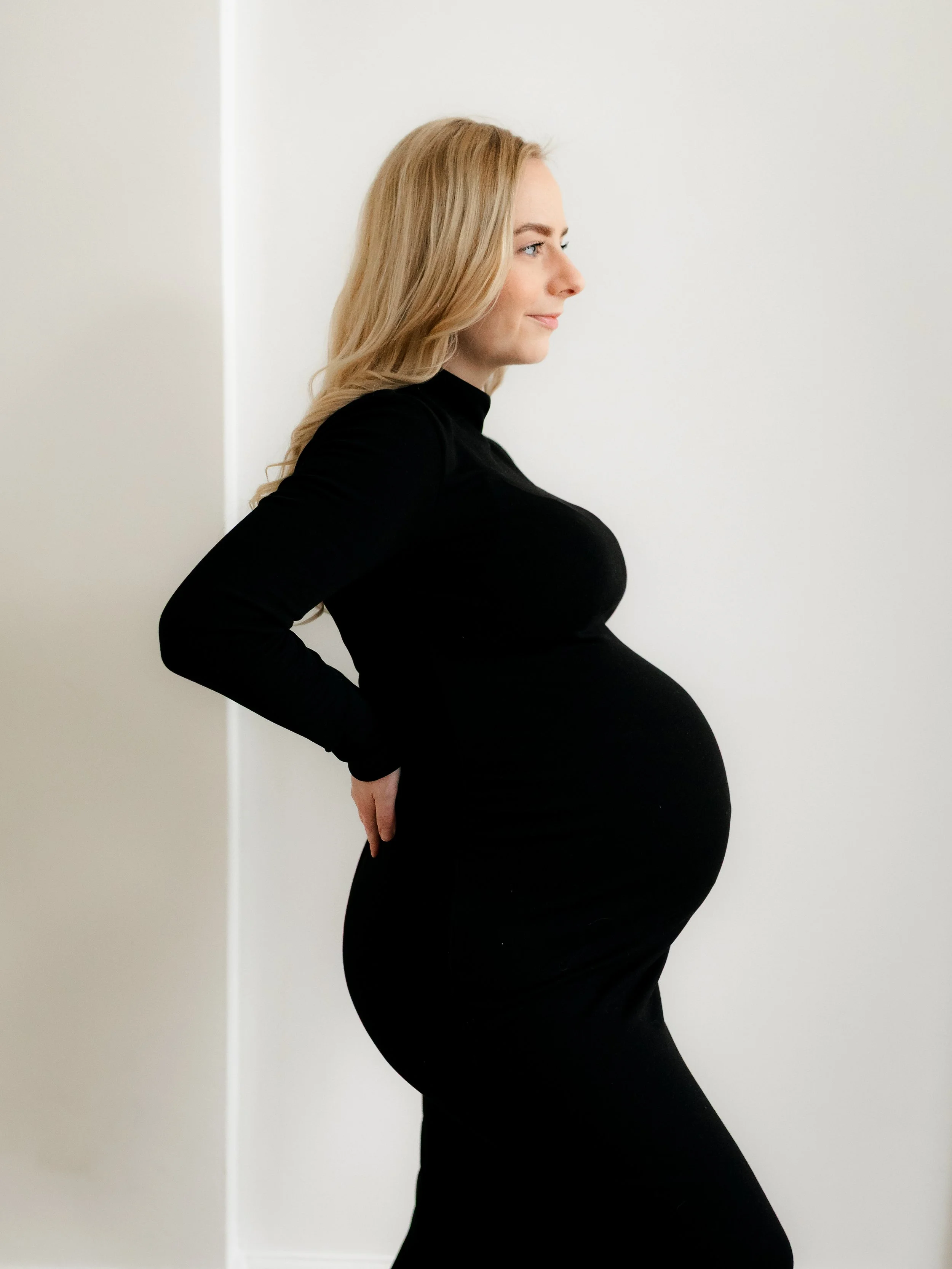 Studio maternity portrait of an expectant mother wearing a black dress in South Ockendon, Essex