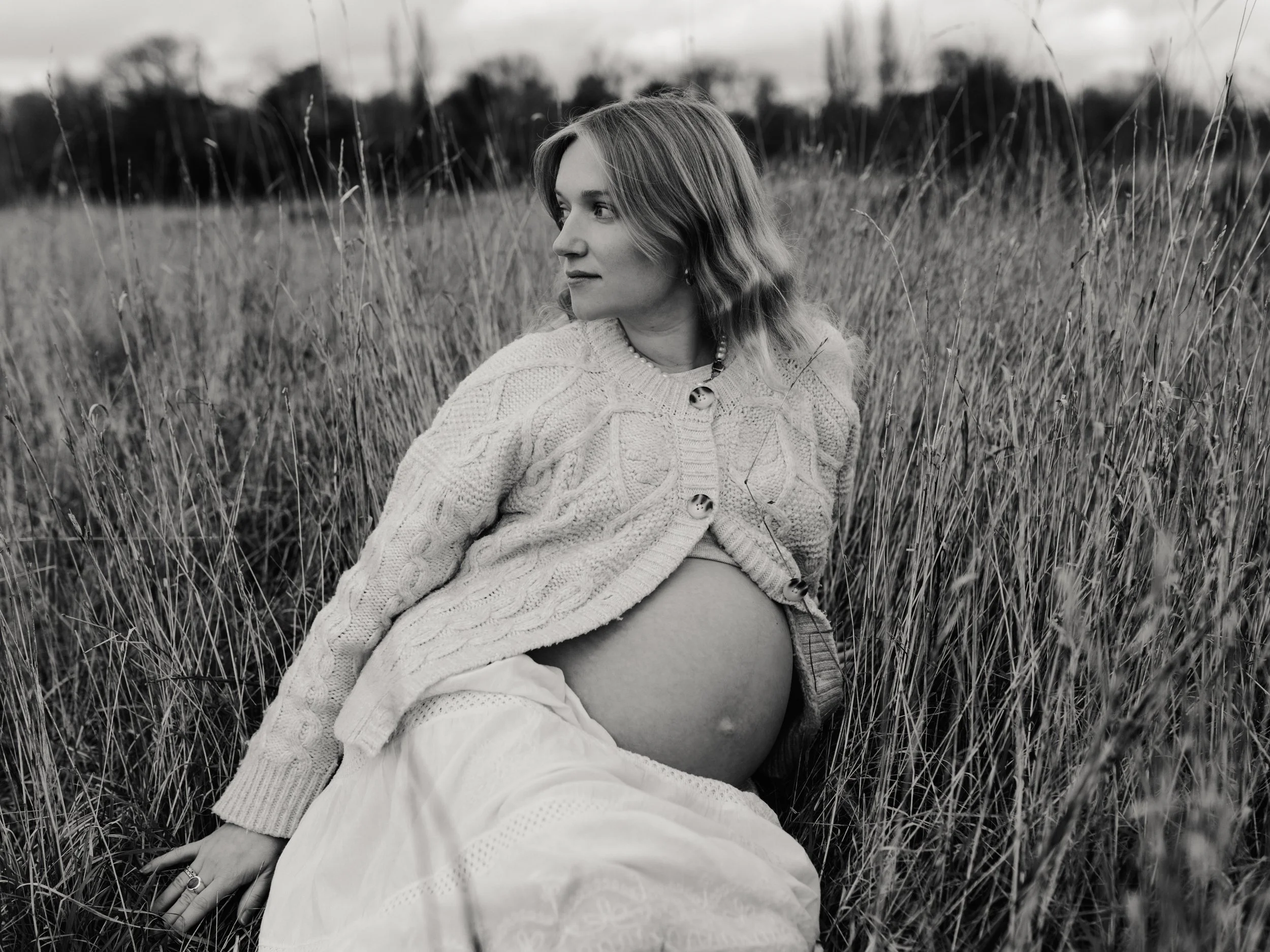 Black and white outdoor maternity portrait of an expectant mother in an Essex field