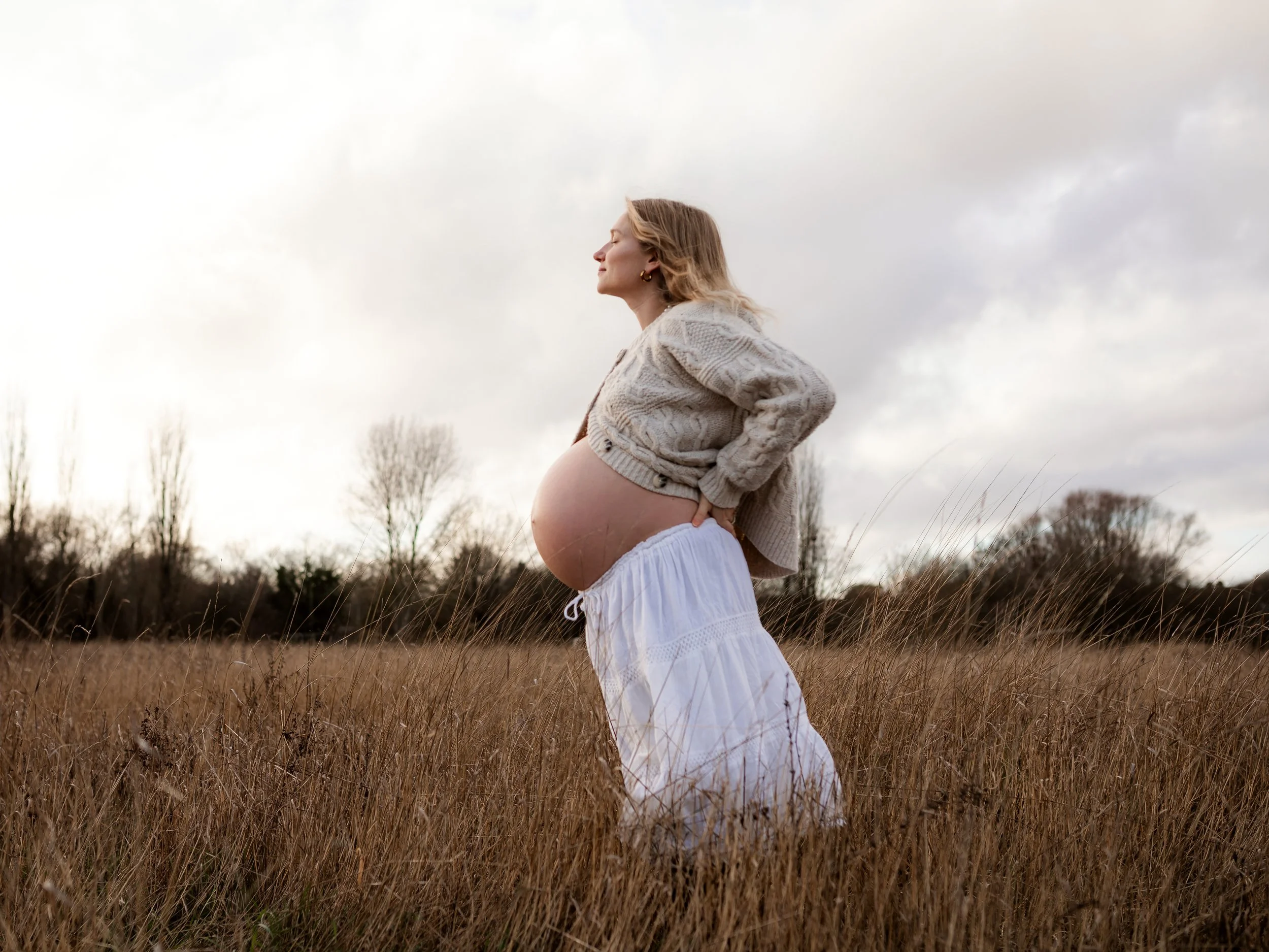 Expectant mother photographed outdoors in an Essex field during her maternity session