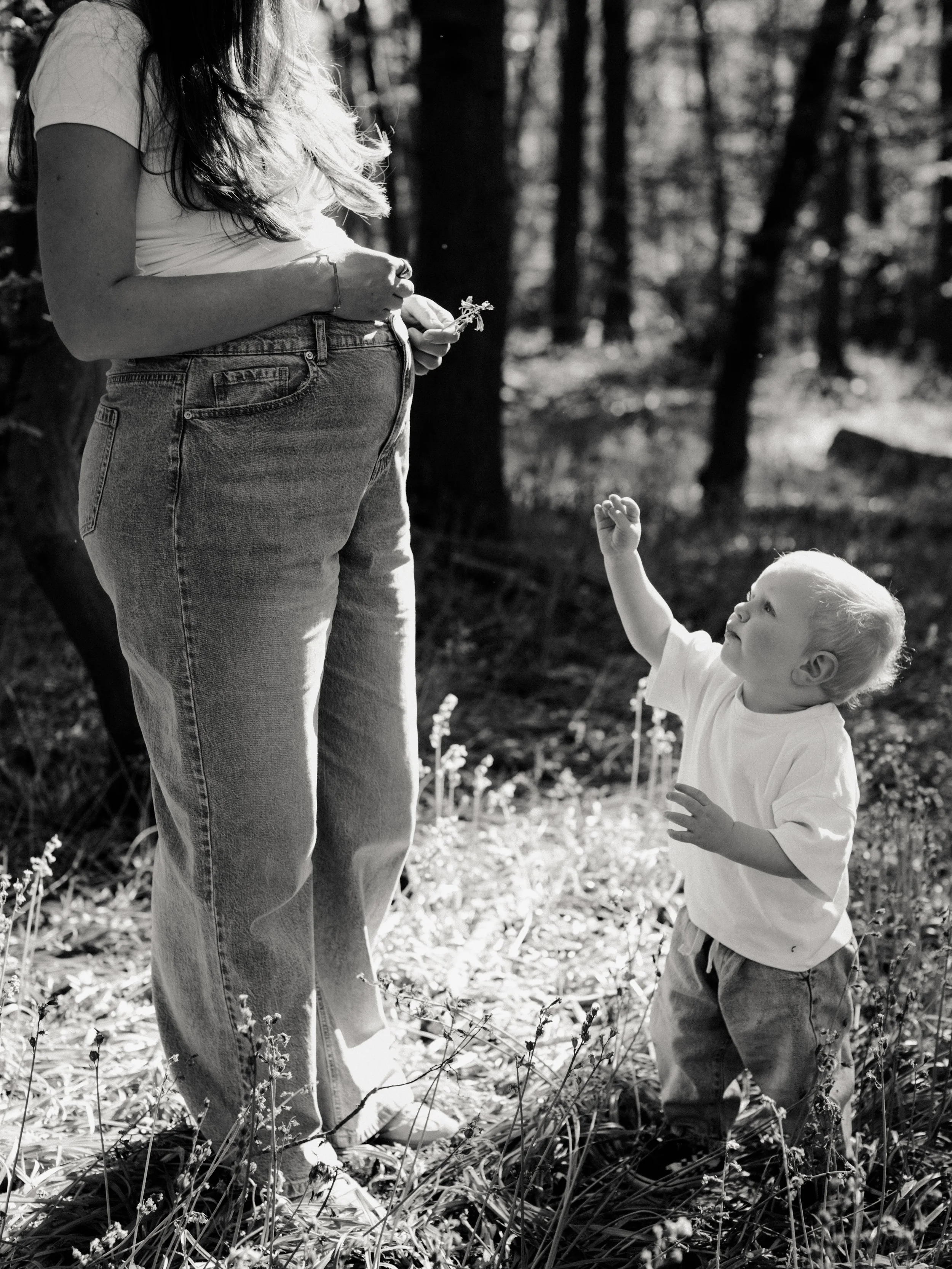 Black and white outdoor maternity portrait of an expectant mother with her young child in Essex