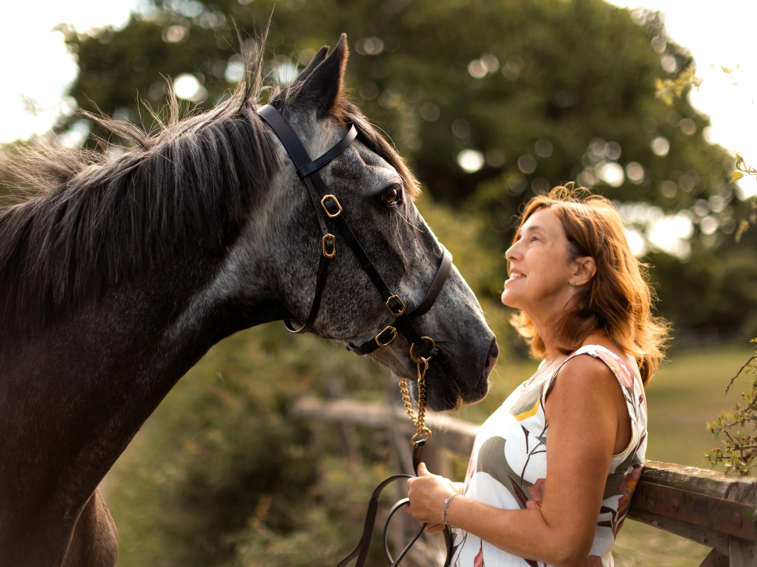 Woman standing with her black horse during a relaxed outdoor equine photography session in Essex.