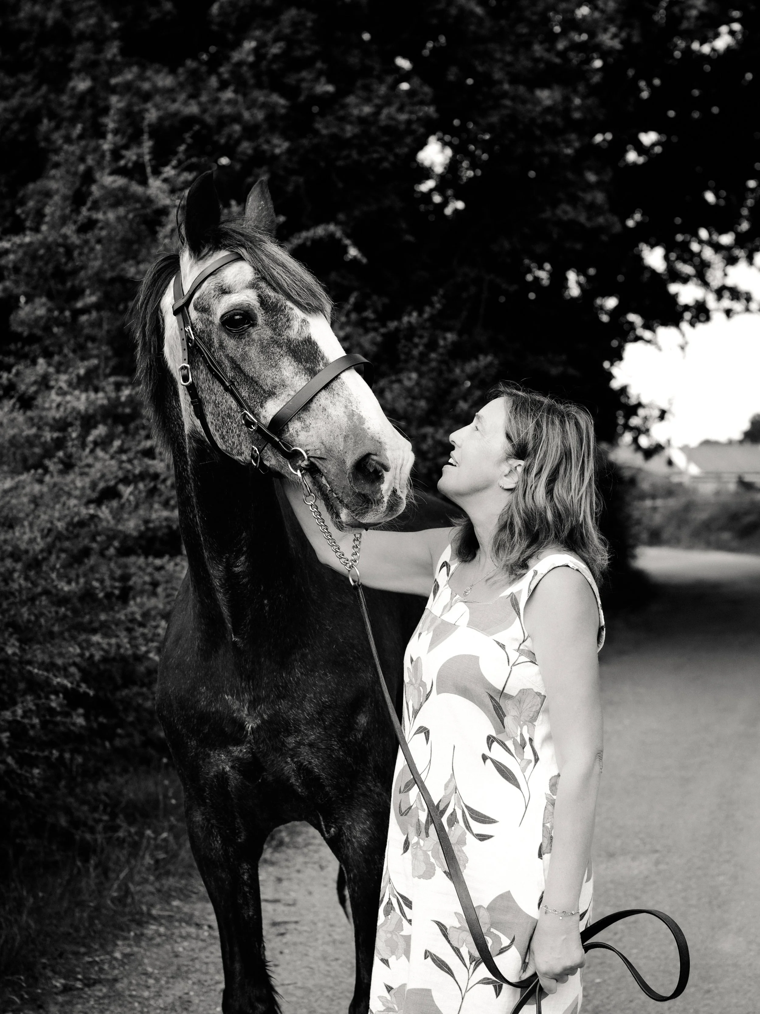 Woman sharing a relaxed moment with her horse during an outdoor equine photography session in Essex.