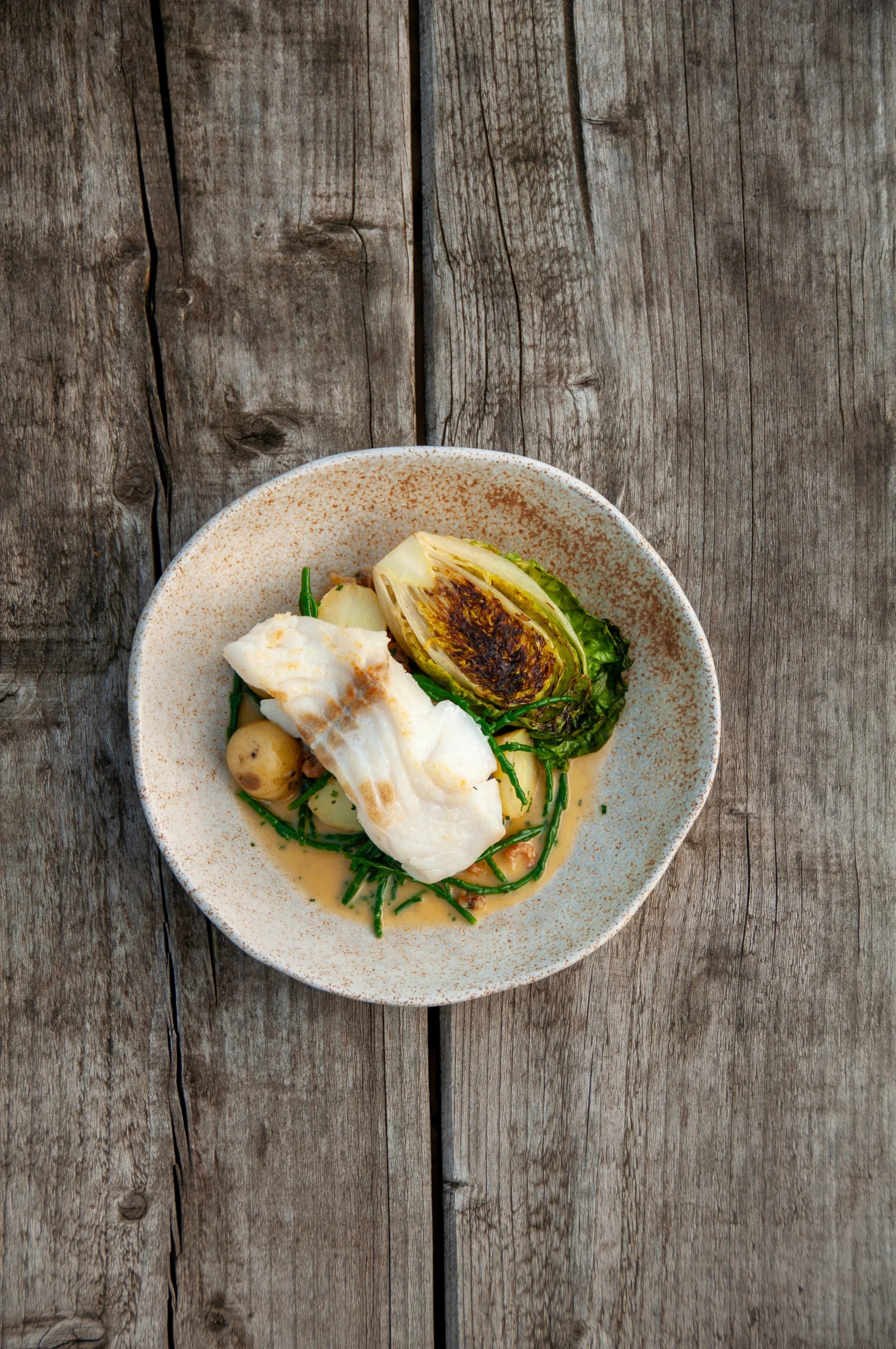 Roast cod, brown butter shrimp, cockles, charred gem, sea veg, buttered Jerseys