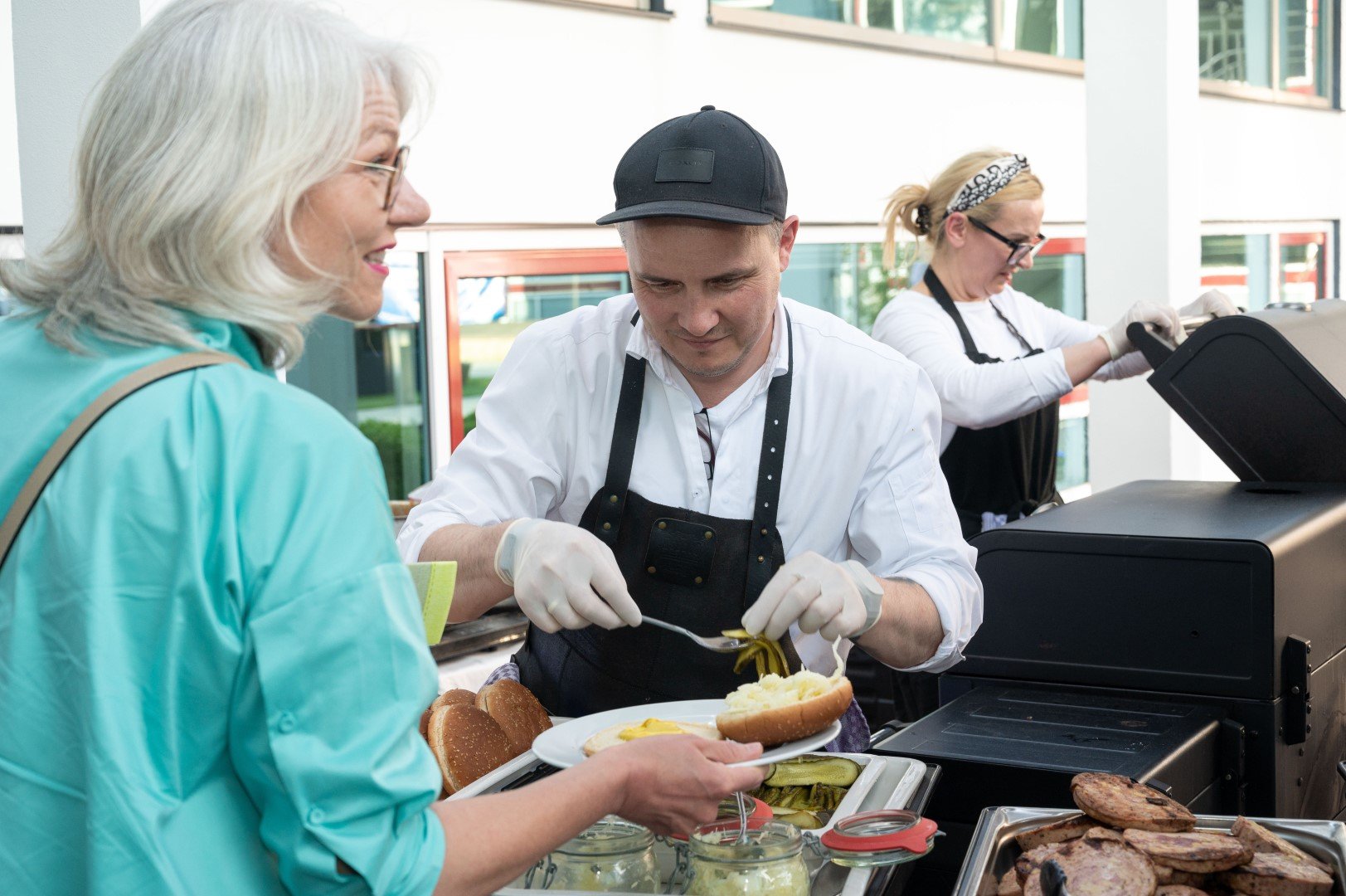 Zwei Menschen, ein Mann und eine Frau, beim Essen an einem Imbissstand.