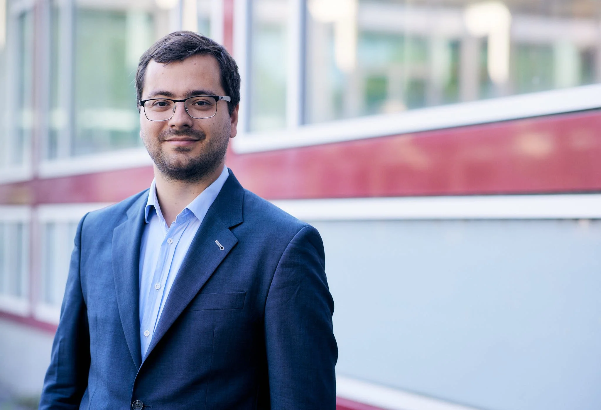 RA Boden von VSZ Rechtsanwälte steht vor einer modernen Gebäude mit großen Fenstern.