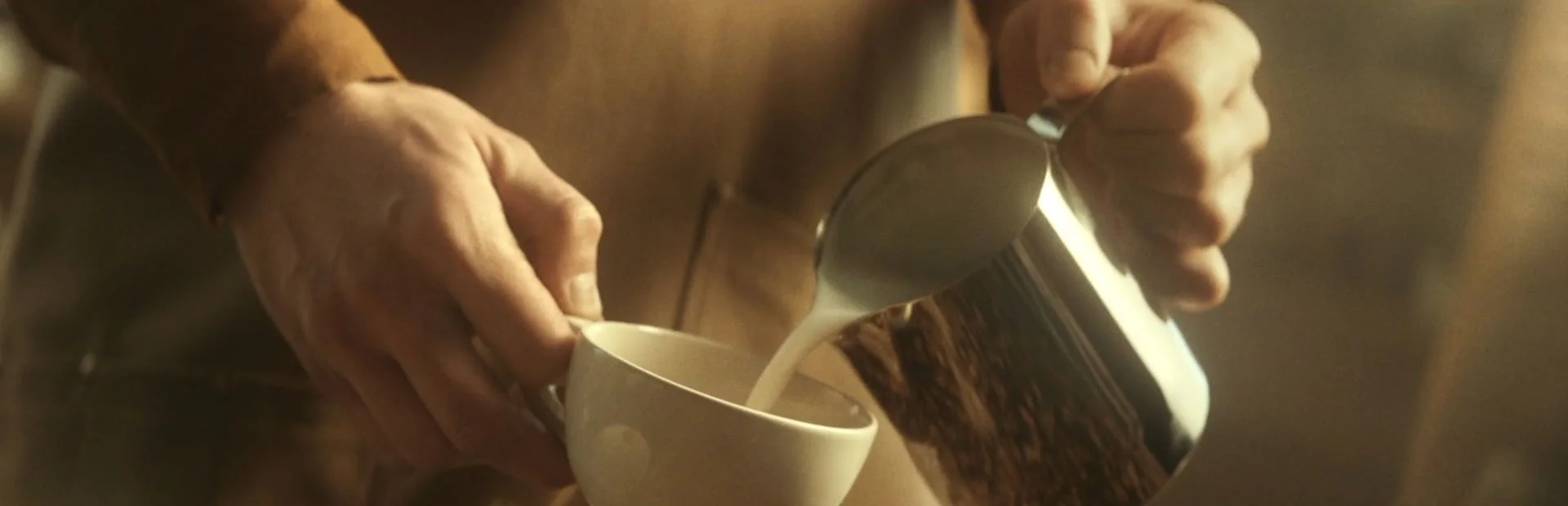 Barista pouring milk