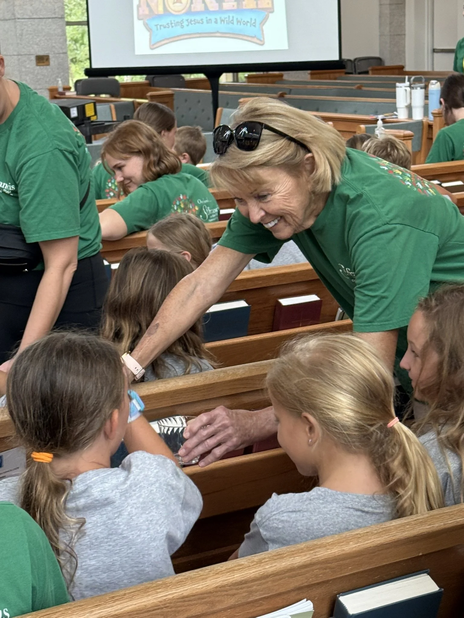 Smiling VBS leader with crew members in sanctuary.JPEG