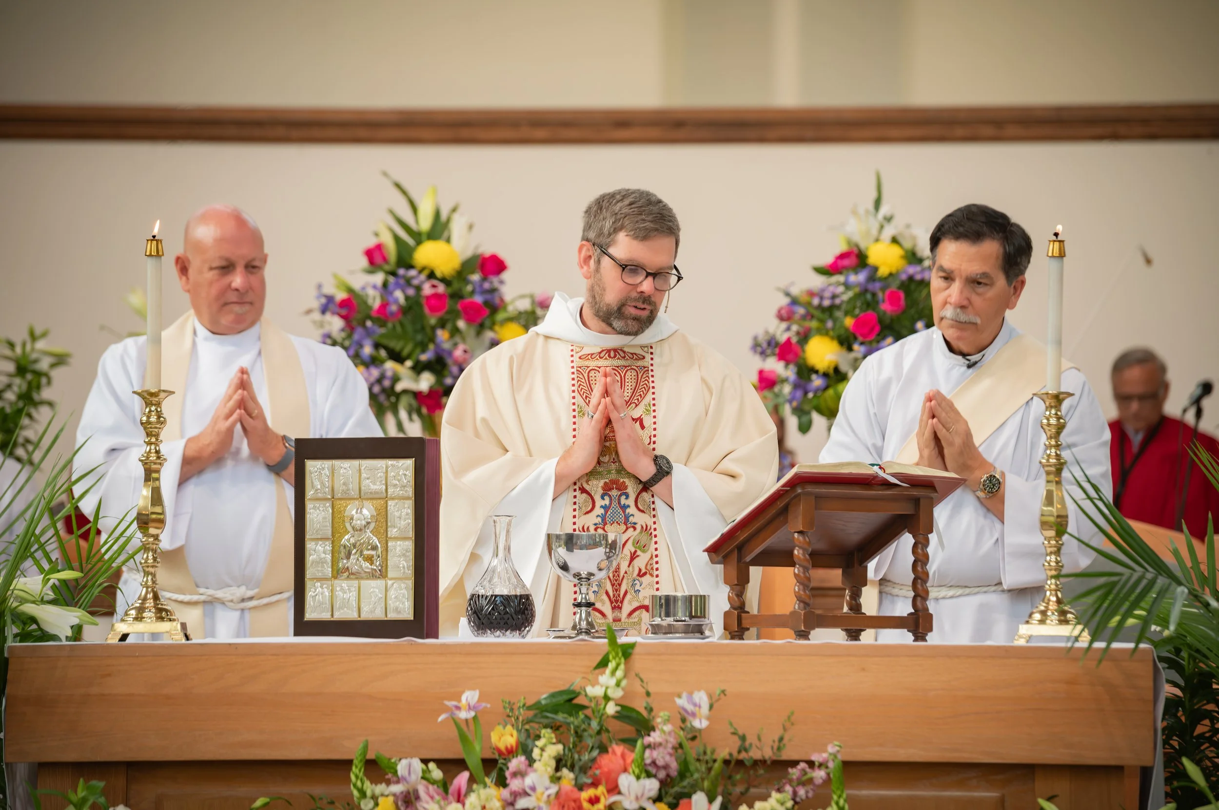 Clergy at altar table preparing to serve communion.