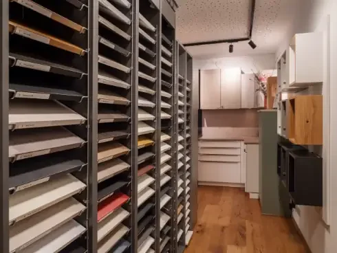 Büro- oder Lagerraum mit Regalen, die verschiedene Fronten-Typen und andere Material-Proben enthalten.