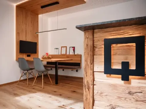 Moderner Sitzecke in einem Küchenatelier. Angeschnitten der Willkommens-Thresen aus Altholz. 