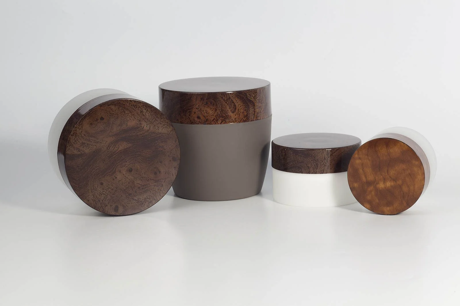 Four modern cylindrical containers with wood-textured lids, varying in size, arranged on a white background.