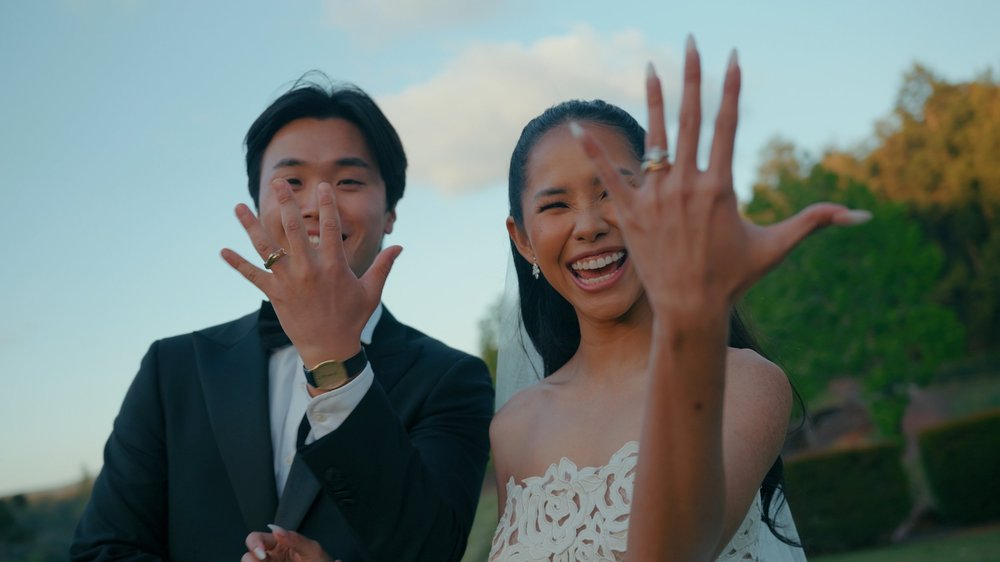 Ory and Johnny laughing and showing their rings