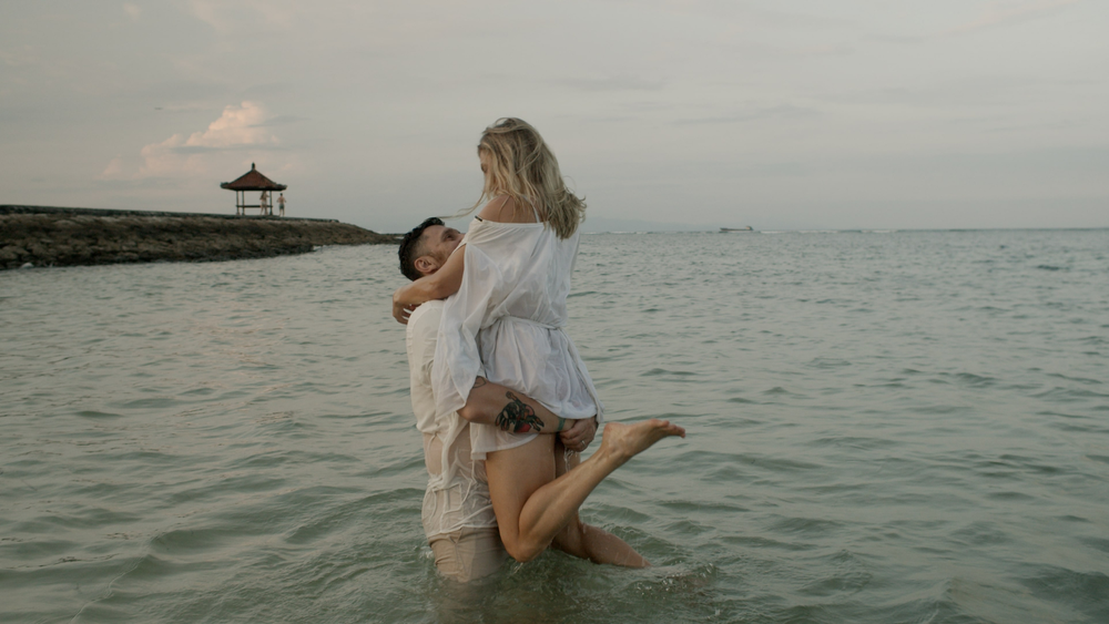 Elias and Lisa embracing in the sea in Bali