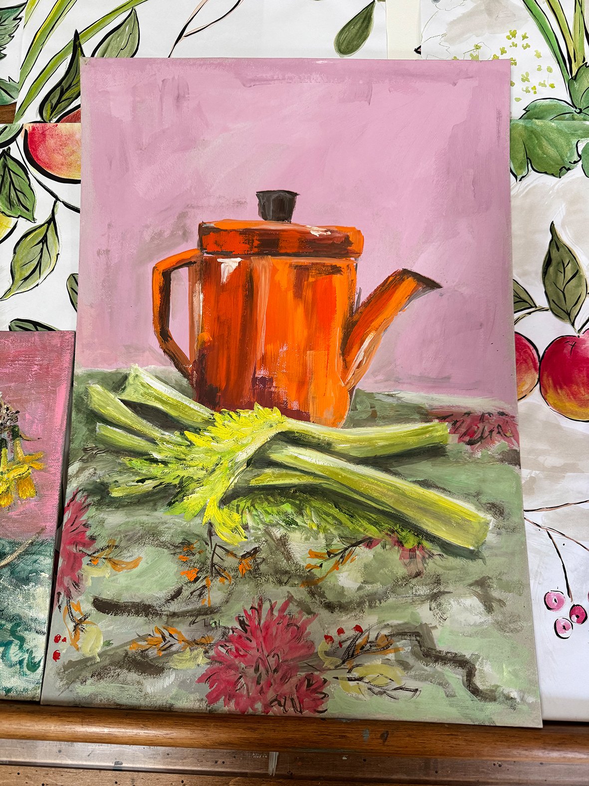 Painting of an orange teapot with a black lid and spout, placed on a table with green vegetables in the foreground.